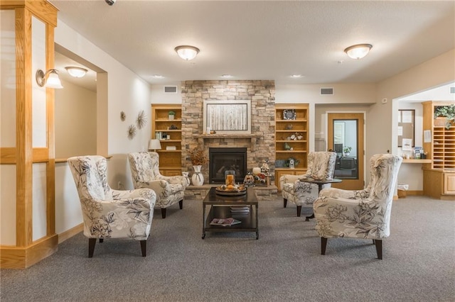 living room featuring carpet flooring, a fireplace, and built in shelves