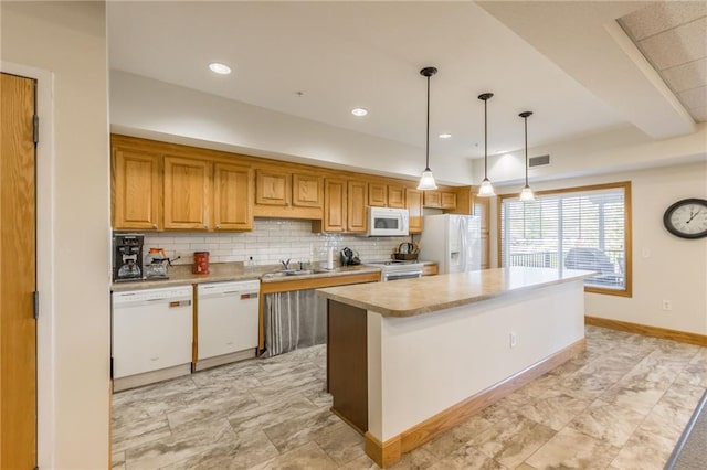 kitchen with sink, hanging light fixtures, white appliances, a center island, and decorative backsplash