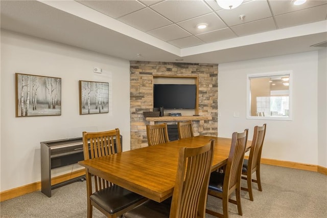 carpeted dining space featuring a drop ceiling