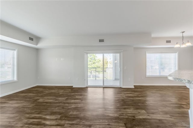 unfurnished room with dark hardwood / wood-style flooring and a notable chandelier