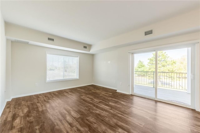 empty room with hardwood / wood-style flooring and a healthy amount of sunlight