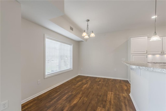 unfurnished dining area with dark hardwood / wood-style flooring and a notable chandelier