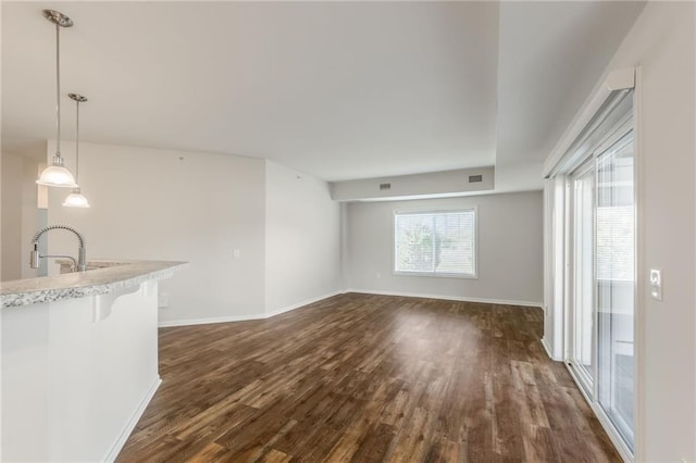 unfurnished living room with dark wood-type flooring