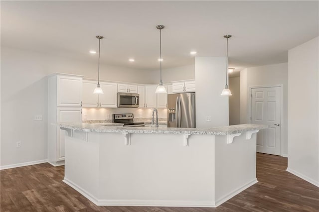 kitchen with stainless steel appliances, hanging light fixtures, white cabinetry, and dark hardwood / wood-style floors