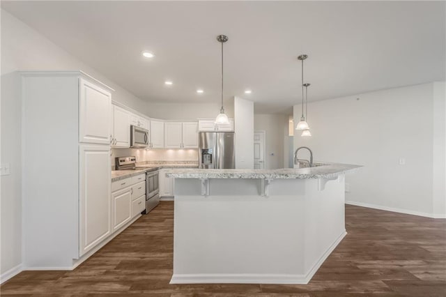 kitchen featuring dark wood-type flooring, white cabinets, a center island with sink, and stainless steel appliances