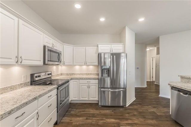 kitchen featuring white cabinets, stainless steel appliances, dark hardwood / wood-style floors, and light stone counters