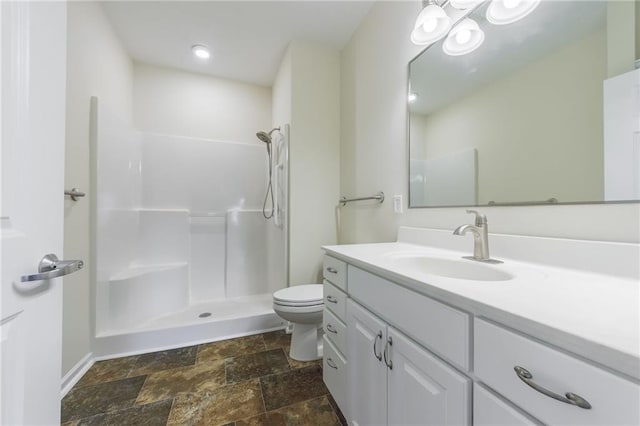 bathroom featuring walk in shower, vanity, and toilet