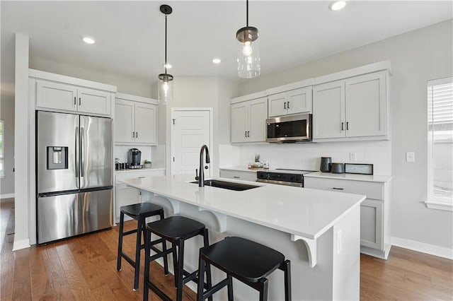 1024 Branchwood Ln, Raymore, MO 64083 - kitchen with appliances with stainless steel finishes, decorative backsplash, dark wood-style floors, recessed lighting, and light countertops
