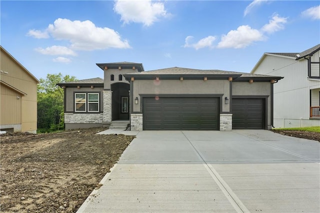 1024 Branchwood Ln, Raymore, MO 64083 - prairie-style house featuring a garage, stucco siding, and driveway