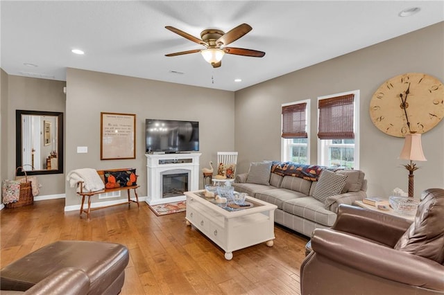 living room with light hardwood / wood-style floors and ceiling fan