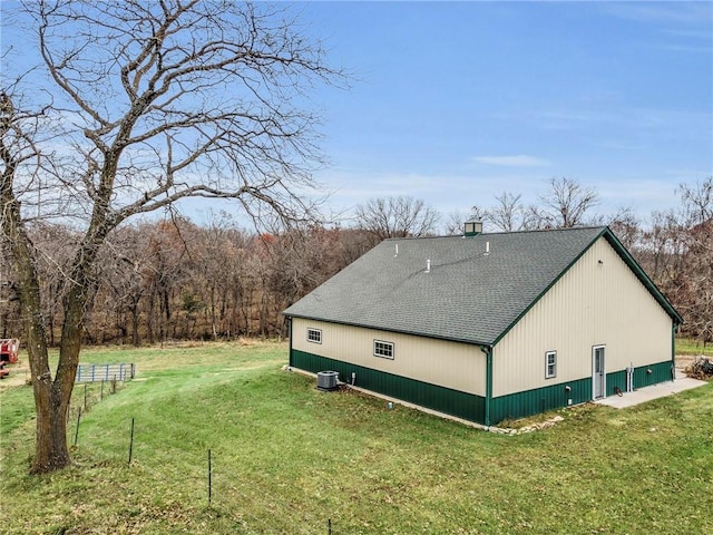 view of property exterior with central air condition unit and a yard