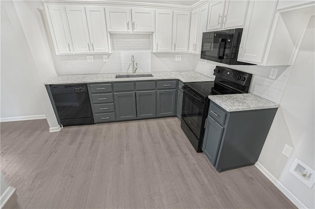 kitchen featuring black appliances, gray cabinetry, white cabinetry, and light hardwood / wood-style floors