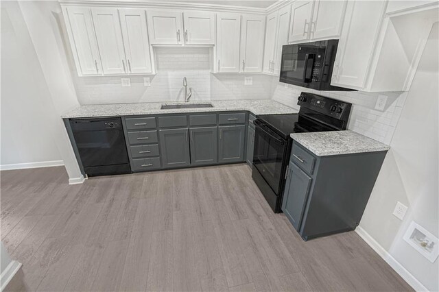 112 W Pine St, Drexel, MO 64742 - kitchen with black appliances, a sink, baseboards, and light wood-style flooring