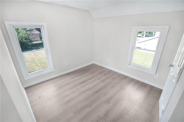 unfurnished room with lofted ceiling and light hardwood / wood-style flooring