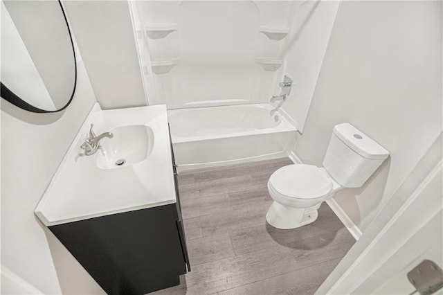 full bathroom with washtub / shower combination, toilet, vanity, and wood-type flooring