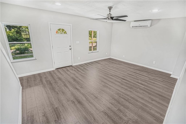 foyer with ceiling fan, a wall mounted AC, and dark hardwood / wood-style floors