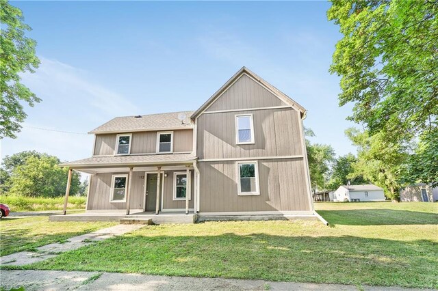 112 W Pine St, Drexel, MO 64742 - view of front of home featuring a porch, a front yard, and a shingled roof