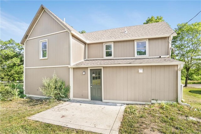 112 W Pine St, Drexel, MO 64742 - traditional-style home featuring roof with shingles, a patio area, and a front lawn