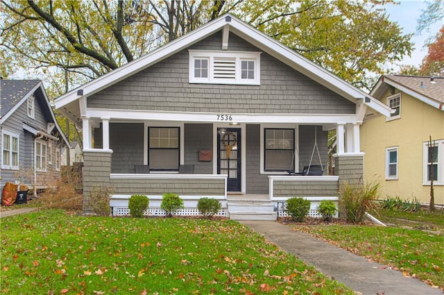 view of front of home featuring covered porch and a front yard