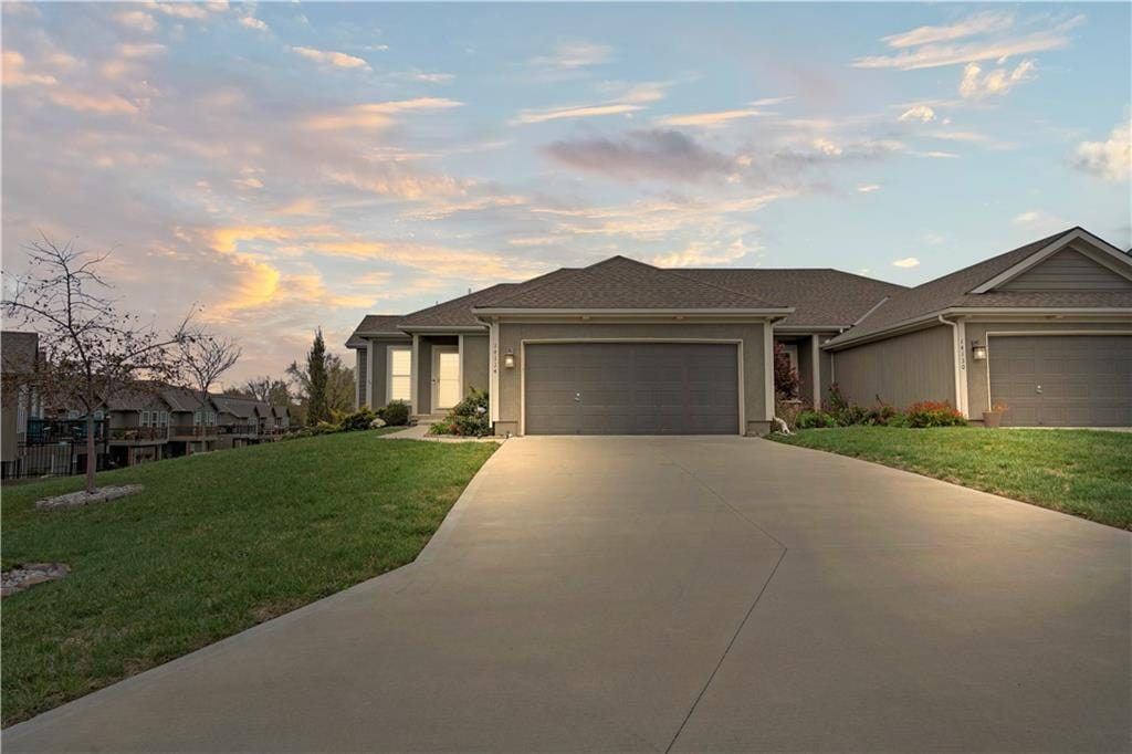 prairie-style home featuring a garage and a yard