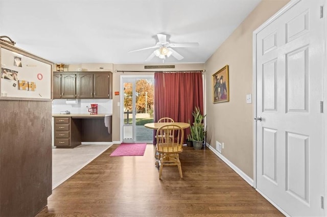 dining room with ceiling fan, hardwood / wood-style floors, and built in desk