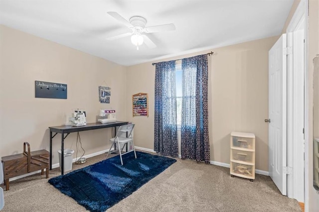 carpeted office space featuring ceiling fan