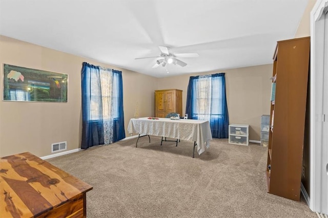 carpeted home office featuring ceiling fan