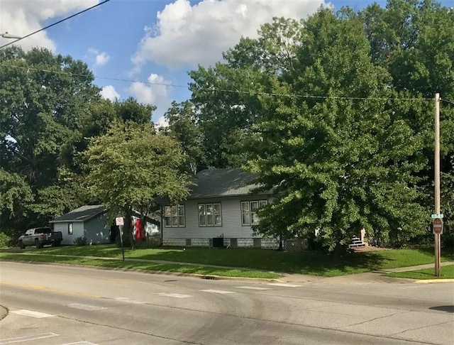 view of property hidden behind natural elements with a front lawn