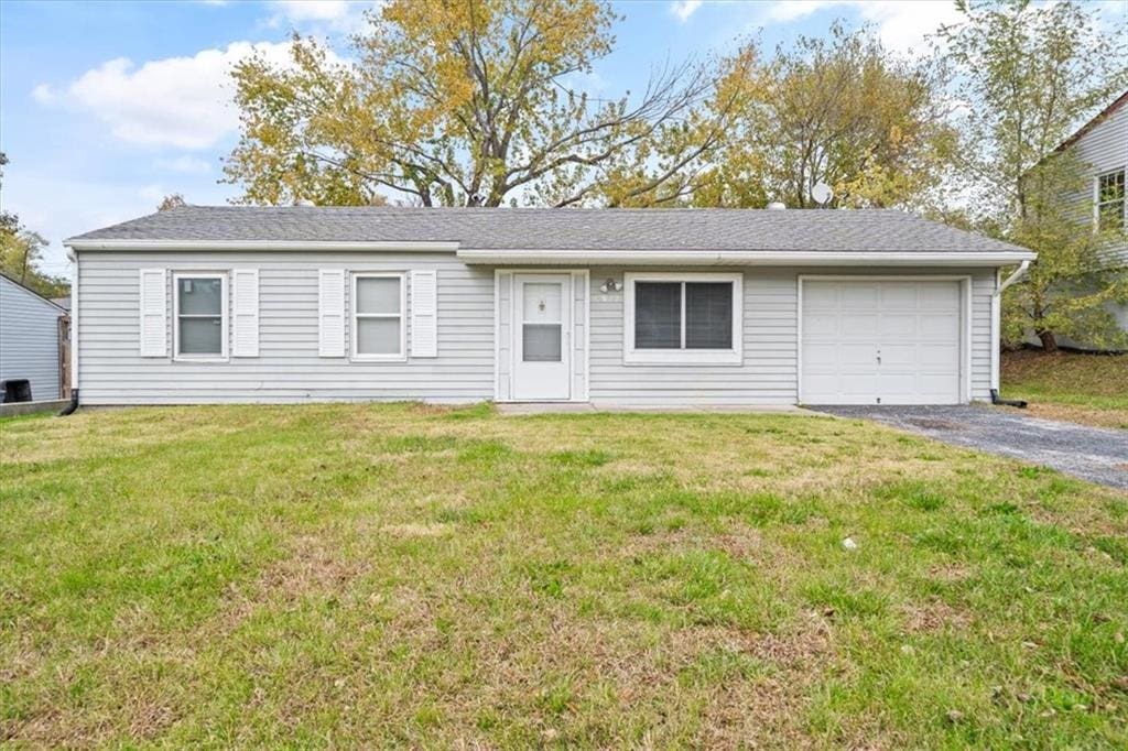 single story home featuring a garage and a front lawn