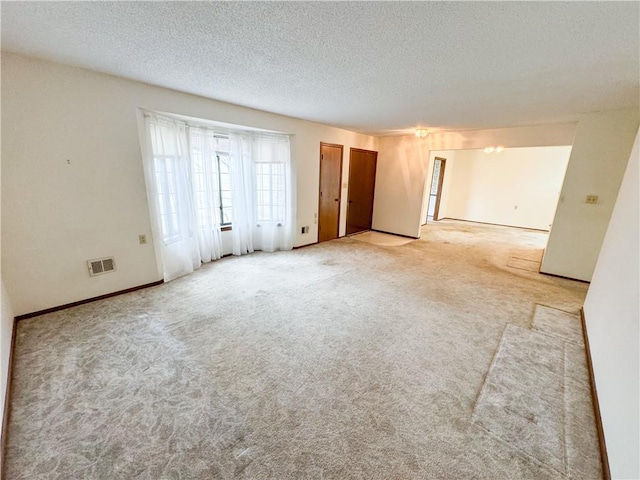 carpeted empty room with a textured ceiling