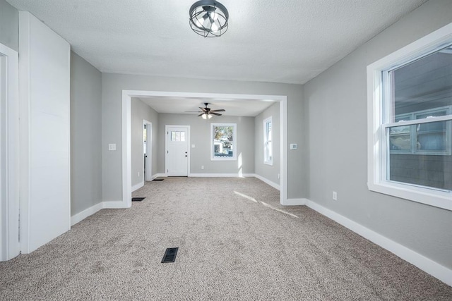 interior space with a textured ceiling and ceiling fan