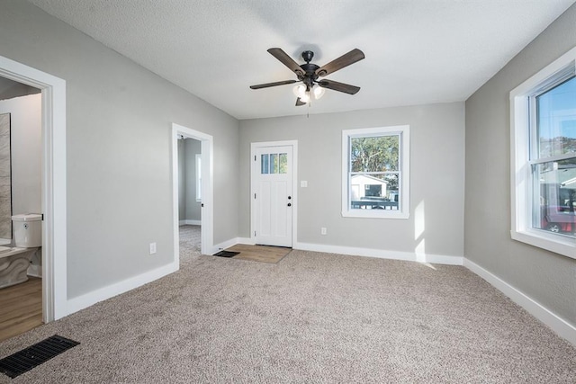 interior space with a textured ceiling and ceiling fan