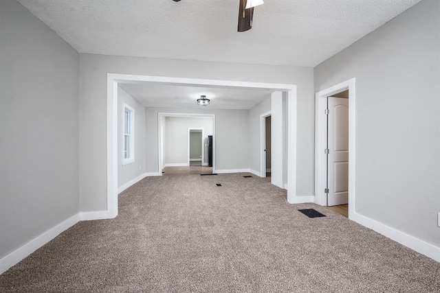 carpeted empty room with a textured ceiling and ceiling fan