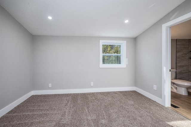 carpeted spare room featuring a textured ceiling