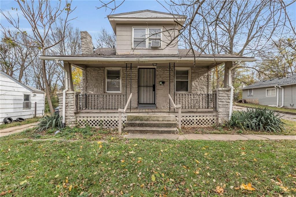 view of front of home with covered porch and a front lawn