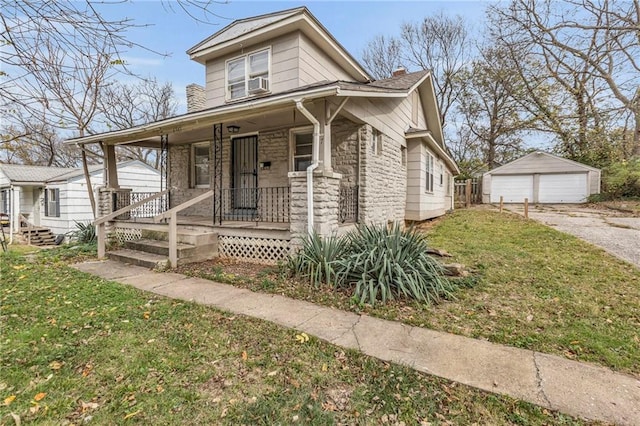 view of front of property with a garage, a porch, a front yard, and an outbuilding