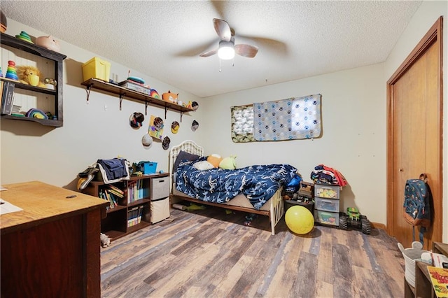 bedroom featuring hardwood / wood-style flooring, ceiling fan, and a textured ceiling