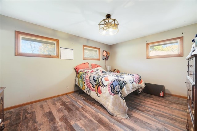 bedroom with dark hardwood / wood-style flooring