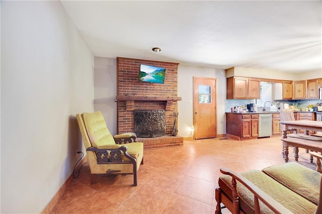 living room featuring light tile patterned flooring, sink, and a fireplace