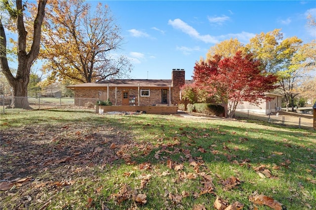 back of property with a yard and a deck