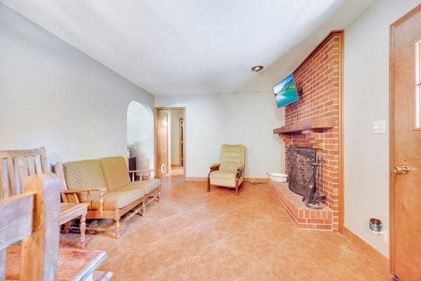 sitting room featuring a brick fireplace