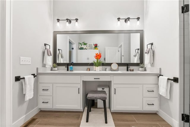 bathroom featuring hardwood / wood-style floors, vanity, and an enclosed shower