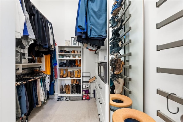 walk in closet featuring light carpet