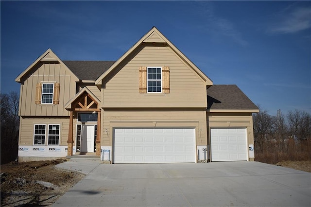 view of front of home featuring roof with shingles, board and batten siding, concrete driveway, and an attached garage