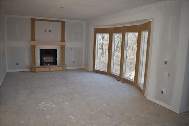 unfurnished living room featuring a fireplace with raised hearth, crown molding, and baseboards