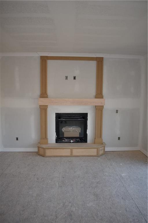 unfurnished living room with baseboards, a fireplace, and crown molding