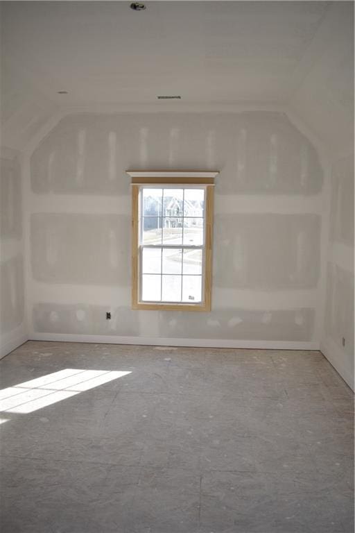 spare room featuring vaulted ceiling