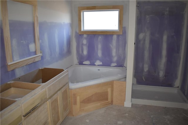 bathroom with vanity, a shower, and a garden tub