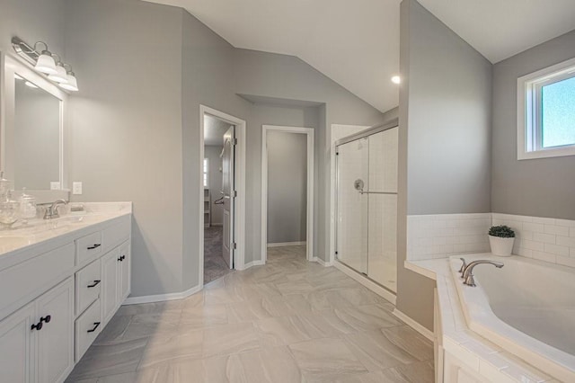 bathroom featuring double vanity, a sink, vaulted ceiling, a shower stall, and a bath