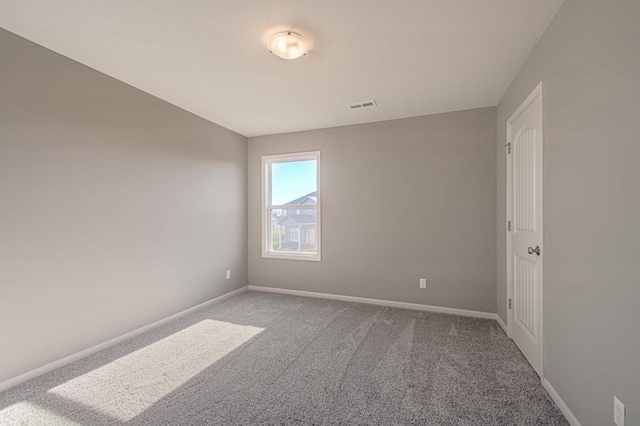 spare room with visible vents, lofted ceiling, baseboards, and carpet floors